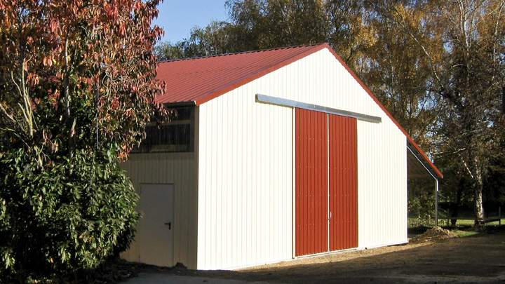 Weiße Maschinenhalle mit Schiebetor.
